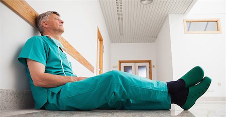 simsearch:400-06734621,k - Surgeon sitting on the floor of hospital corridor Stock Photo - Budget Royalty-Free & Subscription, Code: 400-06799707