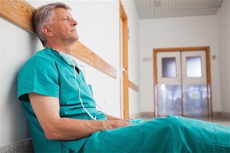 simsearch:400-06734621,k - Tired surgeon is sitting on the floor in hospital corridor wearing green scrubs Stock Photo - Budget Royalty-Free & Subscription, Code: 400-06799708
