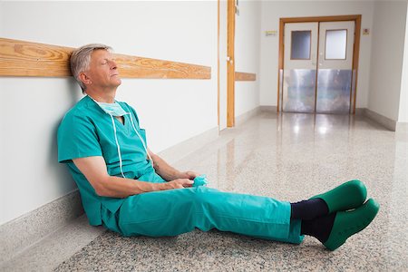 simsearch:400-06734621,k - Doctor is sitting the floor of the corridor in the hospital while eyes closed Stock Photo - Budget Royalty-Free & Subscription, Code: 400-06799710