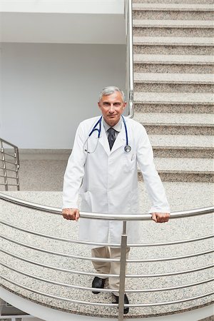 simsearch:400-06799599,k - Smiling doctor  leaning on the railing of the stairs in the hospital Foto de stock - Super Valor sin royalties y Suscripción, Código: 400-06799745