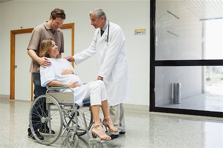 doctor speak with pregnant - Pregnant woman with in wheelchair with partner talks to doctor in the hospital corridor Stock Photo - Budget Royalty-Free & Subscription, Code: 400-06799755