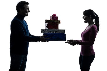 one caucasian couple woman man offering christmas  gifts in silhouette studio isolated on white background Stock Photo - Budget Royalty-Free & Subscription, Code: 400-06790392