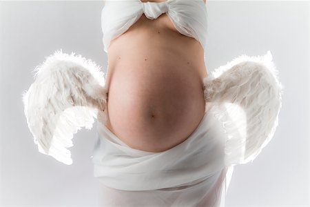 Pregnancy. Woman with wings attached to belly. Foto de stock - Super Valor sin royalties y Suscripción, Código: 400-06790501