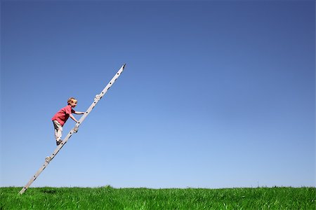 Young boy climbs a ladder on green meadow with blue sky Stock Photo - Budget Royalty-Free & Subscription, Code: 400-06790750