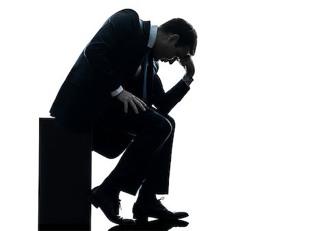 simsearch:400-06794896,k - one caucasian sad business man  sitting pensive looking down  in silhouette studio isolated on white background Stock Photo - Budget Royalty-Free & Subscription, Code: 400-06790834