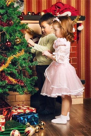 funny present christmas - beautiful boy and girl decorate christmas tree Stock Photo - Budget Royalty-Free & Subscription, Code: 400-06790898
