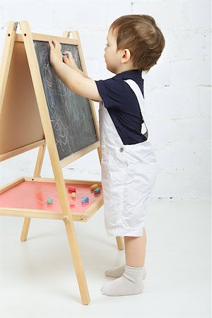 little boy drawing with chalk at blackboard Stock Photo - Budget Royalty-Free & Subscription, Code: 400-06790932