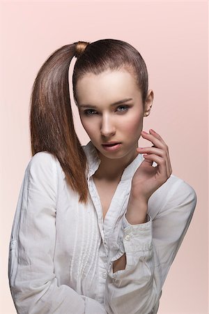 simsearch:400-06790945,k - sensual young lady with brown hair, white shirt and brown smooth ponytail looking in camera Photographie de stock - Aubaine LD & Abonnement, Code: 400-06790943