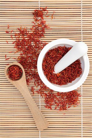 simsearch:400-06521200,k - Saffron spice in a mortar with pestle and wooden spoon over bamboo background. Stockbilder - Microstock & Abonnement, Bildnummer: 400-06790961