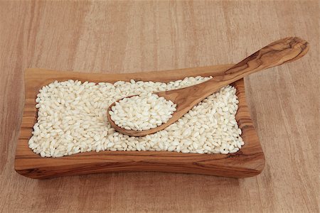 simsearch:400-06790178,k - Risotto arborio short grain rice in an olive wood bowl with spoon over papyrus background. Foto de stock - Super Valor sin royalties y Suscripción, Código: 400-06791004
