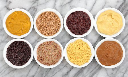 dijon - Mustard selection of powder, seed, french, dijon, english and wholegrain in white porcelain bowls over marble background. Foto de stock - Royalty-Free Super Valor e Assinatura, Número: 400-06791002