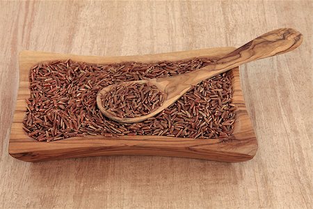 simsearch:400-06790178,k - Bhutanese red rice in an olive wood bowl with spoon over papyrus background. Foto de stock - Super Valor sin royalties y Suscripción, Código: 400-06791139