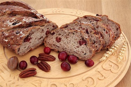 simsearch:640-01354973,k - Cranberry and pecan bread on a beech wood bread board over oak background. Foto de stock - Royalty-Free Super Valor e Assinatura, Número: 400-06791587