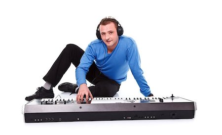 Young man posing with synthesizer and headset over white background Foto de stock - Royalty-Free Super Valor e Assinatura, Número: 400-06791693