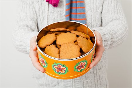 Tin of gingerbread biscuits being held up and presented by man wearing scalf Stock Photo - Budget Royalty-Free & Subscription, Code: 400-06791793