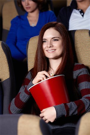 Smiling girl with popcorn at the cinema Stock Photo - Budget Royalty-Free & Subscription, Code: 400-06792889