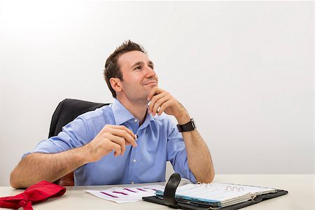 simsearch:400-05718341,k - Young executive holding his chin on his hand and lost in happy thoughts at work. Stock Photo - Budget Royalty-Free & Subscription, Code: 400-06793049