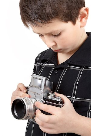 film making - young boy with old vintage analog SLR camera looking to viewfinder Stock Photo - Budget Royalty-Free & Subscription, Code: 400-06793364