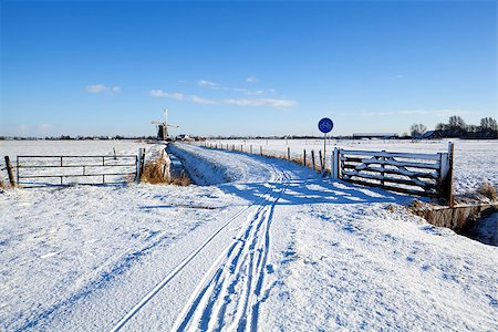 snow road horizon - bicycle road by Dutch windmill in snowy winter Foto de stock - Super Valor sin royalties y Suscripción, Código: 400-06793639