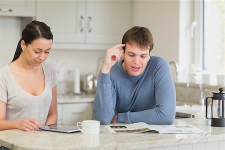 Two people sitting in a kitchen while they are talking and reading and drinking coffee Stock Photo - Budget Royalty-Free & Subscription, Code: 400-06800205