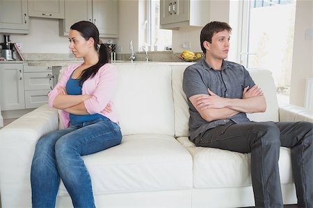 sad and quiet woman - Two people sitting on the couch with crossing arms and falling quiet in the living room Stock Photo - Budget Royalty-Free & Subscription, Code: 400-06800236