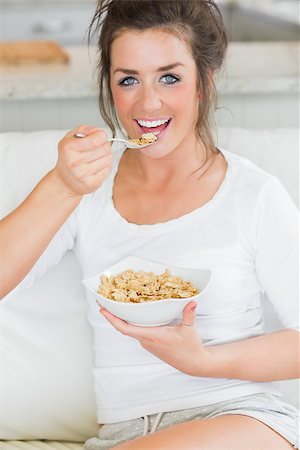 simsearch:693-07542090,k - Happy girl eating bowl of cereal on couch Stockbilder - Microstock & Abonnement, Bildnummer: 400-06800422
