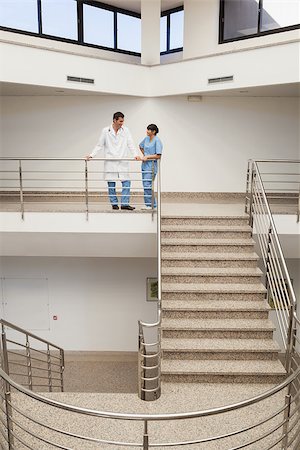 simsearch:400-06799497,k - Nurse and doctor talking at top of hospital stairwell Stockbilder - Microstock & Abonnement, Bildnummer: 400-06800600