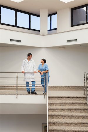 simsearch:400-06799497,k - Nurse and doctor having a discussion at top of hospital stairwell Stockbilder - Microstock & Abonnement, Bildnummer: 400-06800601