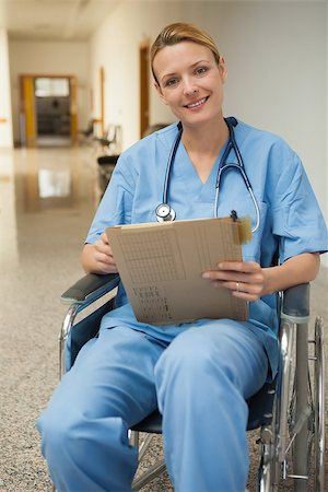 paraplegic women in wheelchairs - Smiling nurse checking her notes in a wheelchair in hospital corridor Stock Photo - Budget Royalty-Free & Subscription, Code: 400-06800634