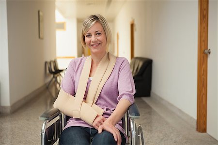 Patient in wheelchair with arm in sling in hospital corridor Stockbilder - Microstock & Abonnement, Bildnummer: 400-06800630