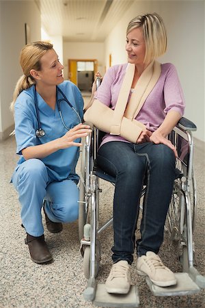 Nurse talking with patient in wheelchair with arm in sling in hospital hallway Foto de stock - Super Valor sin royalties y Suscripción, Código: 400-06800632