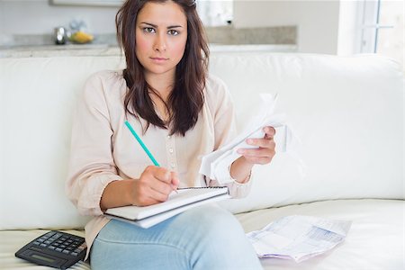 simsearch:400-06803524,k - Young woman looking stressed over bills on sofa Stock Photo - Budget Royalty-Free & Subscription, Code: 400-06801014