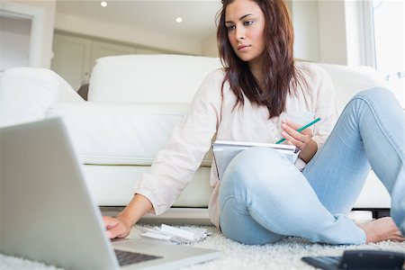 simsearch:400-06803524,k - Woman typing on the ;laptop and comparing bills on floor of living room Stock Photo - Budget Royalty-Free & Subscription, Code: 400-06801035