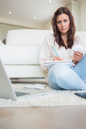 simsearch:400-06803524,k - Woman writing on a paper while calculating bills Stock Photo - Budget Royalty-Free & Subscription, Code: 400-06801036