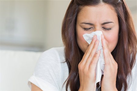 simsearch:400-06801081,k - Burnette woman blowing nose into tissue Photographie de stock - Aubaine LD & Abonnement, Code: 400-06801081