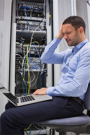 simsearch:400-06801216,k - Worker looking stressed with laptop in data center Foto de stock - Royalty-Free Super Valor e Assinatura, Número: 400-06801224