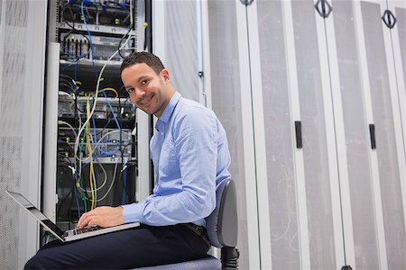 simsearch:400-06801216,k - Smiling man working on the servers in data center Foto de stock - Royalty-Free Super Valor e Assinatura, Número: 400-06801223