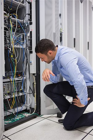 simsearch:400-06801216,k - Technician looking at cables of the server in data center Foto de stock - Royalty-Free Super Valor e Assinatura, Número: 400-06801237