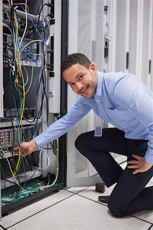 simsearch:400-06801216,k - Smiling man adjusting cable in the server in data center Foto de stock - Royalty-Free Super Valor e Assinatura, Número: 400-06801239