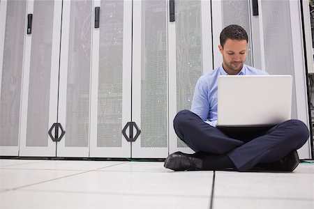 simsearch:400-06801216,k - Technician sitting on floor working on laptop in data center Foto de stock - Royalty-Free Super Valor e Assinatura, Número: 400-06801334