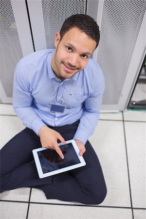 simsearch:400-06801216,k - Smiling man using tablet pc beside servers in data center Foto de stock - Royalty-Free Super Valor e Assinatura, Número: 400-06801349