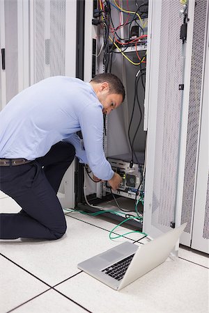 simsearch:400-06801216,k - Man doing maintenance and fixing wires on server in data center Foto de stock - Royalty-Free Super Valor e Assinatura, Número: 400-06801353