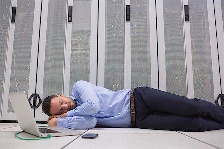 Man sleeping while doing maintenance on servers with laptop Stock Photo - Budget Royalty-Free & Subscription, Code: 400-06801360