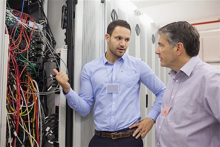 simsearch:400-06801216,k - Two technicians discussing wiring in data center Foto de stock - Royalty-Free Super Valor e Assinatura, Número: 400-06801403