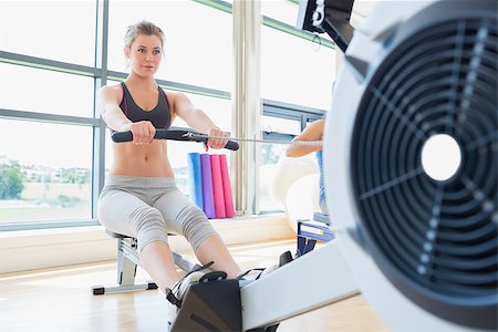 simsearch:400-06801591,k - Woman exercising on row machine in fitness studio Foto de stock - Super Valor sin royalties y Suscripción, Código: 400-06801582