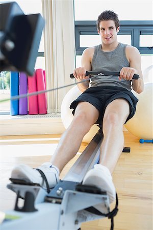 simsearch:400-06801591,k - Man sitting at the row machine at the gym smiling Stock Photo - Budget Royalty-Free & Subscription, Code: 400-06801593