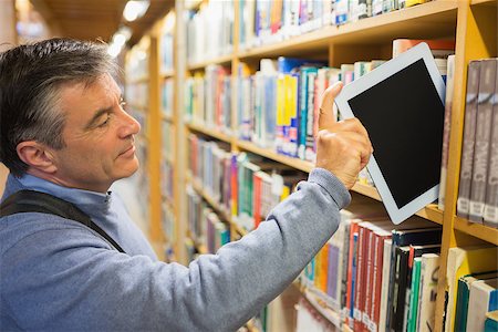 Man taking a tablet pc from the shelves in a library Stock Photo - Budget Royalty-Free & Subscription, Code: 400-06801635