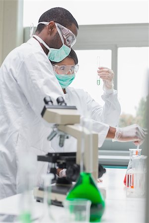 simsearch:6109-07497816,k - Chemists viewing liquids in the laboratory Fotografie stock - Microstock e Abbonamento, Codice: 400-06801663