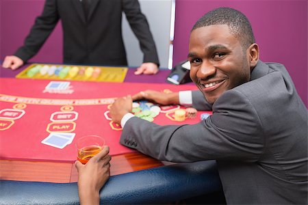 Happy man taking his winnings in poker game in casino Stock Photo - Budget Royalty-Free & Subscription, Code: 400-06801835