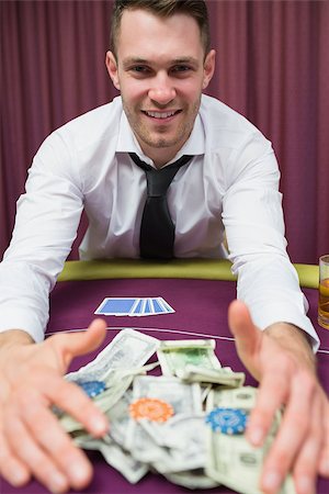 Happy man at poker table taking his winnings in casino Stock Photo - Budget Royalty-Free & Subscription, Code: 400-06801872